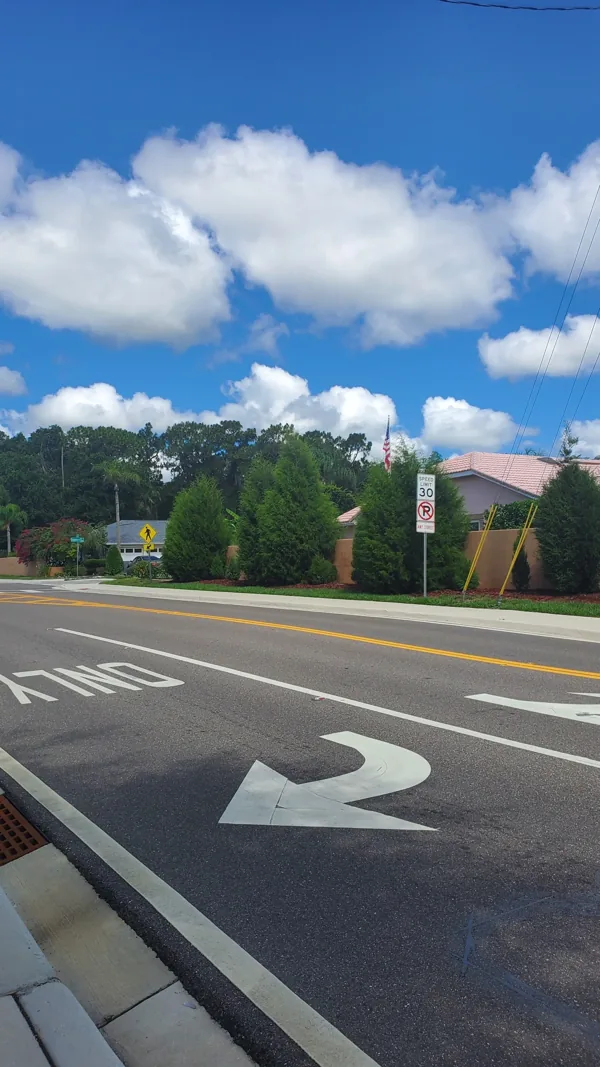 A street with an arrow pointing to the right on a sunny day.